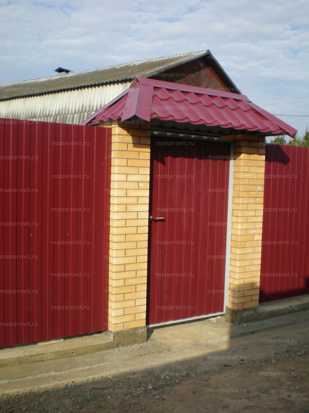 Готовый красный забор из профнастила с калиткой и кирпичными столбами