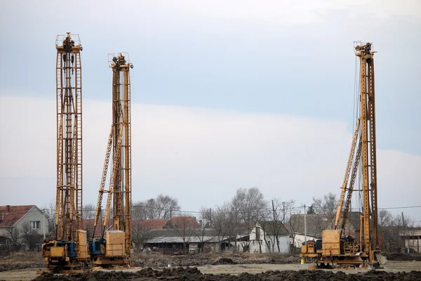Три машины гидравлические буровые на строительной площадке — стоковое изображение Три машины гидравлические буровые на строительной площадке Стоковое Изображение